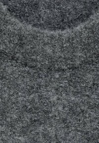 Tissu en laine texturé gris avec une surface douce et pelucheuse, présentant un mélange de fils gris foncé et clair partout.