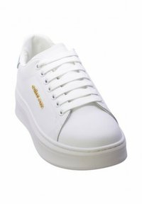 Sneaker bianco con tomaia in pelle liscia, lacci piatti e dettagli dorati sul lato. Suola in gomma bianca spessa.