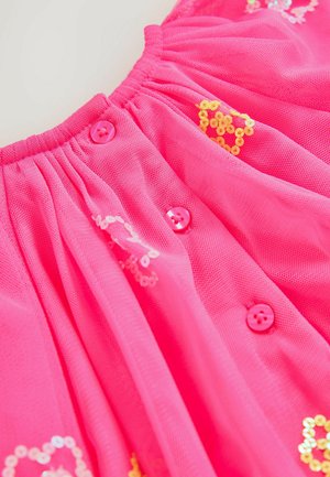 Rosa Tüllkleid mit einem gerafften Taillenbund, verziert mit rosa Knöpfen und gelben Paillettenshaped Herzmuster.
