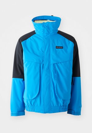 Veste imperméable bleue et noire avec col montant, deux poches avant, poignets élastiques et ourlet ajustable. Texture lisse avec des détails de couture.