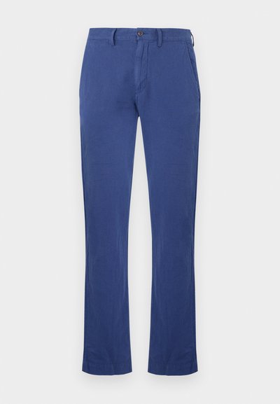 Kék lenvászon nadrág egyenes szárú kialakítással, elülső zsebekkel, gombos záródással és sima, puha anyagú textúrával.