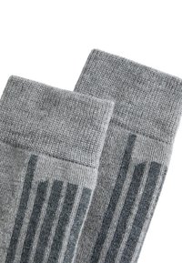 Szare wełniane skarpetki z prążkowanym wykończeniem i subtelnym wzorem w zygzak po bokach. Wykonane z miękkiej, teksturowanej tkaniny dla zapewnienia komfortu.