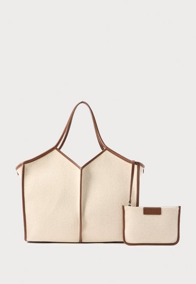 Sac fourre-tout en toile beige avec garniture et poignées en cuir marron, accompagné d'une petite pochette assortie zippée attachée.