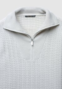 Maglione a collo alto con zip a metà in maglia grigio chiaro, caratterizzato da un motivo strutturato e una piccola tasca sotto il colletto. Taglia L visibile.