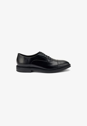Zapato de dress de cuero negro con punta redondeada, textura suave, costuras a tono, diseño con cordones y suela plana de goma.