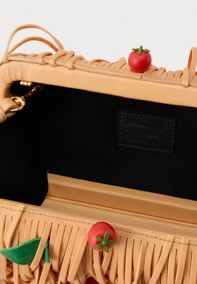 Bežinė odinė rankinė su frangiruotėmis, žalia lapų ir raudonų pomidorų akcentais; juodas vidus su matomu prekės ženklu pažymėtu odiniu žymeniu.