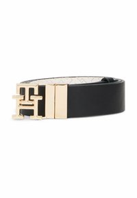 Ceinture en cuir noir enroulée avec une boucle en métal doré en forme de la lettre H, présentée sur un fond blanc.