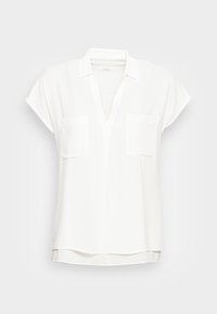 Blusa bianca con scollatura a V, maniche corte a cappuccio e due taschini frontali. Tessuto morbido con una superficie liscia e spacchi laterali all'orlo.