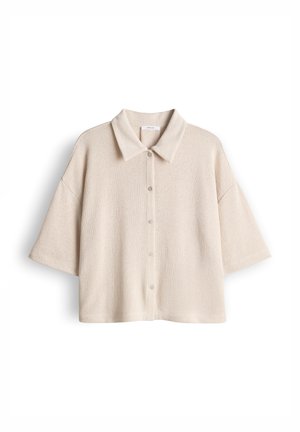 Beige overhemd met korte mouwen, knoopsluiting, kraag en losse pasvorm, afgebeeld tegen een witte achtergrond.