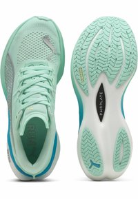Zapatillas de running de color verde menta claro con parte superior de malla transpirable, detalles plateados y una suela de goma texturizada que presenta patrones de tracción.