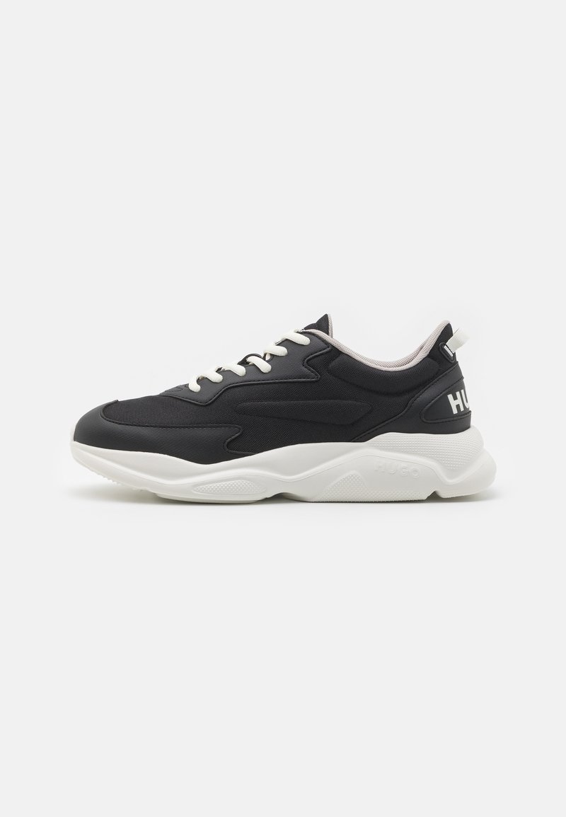 Chaussures de sport noires avec un design texturé, dotées d'une semelle et de lacets blancs. Logo "HUGO" au talon, soulignant un style moderne.