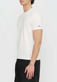 T-shirt bianco in cotone a maniche corte, con un logo rosso e nero sulla manica sinistra. Tessuto morbido e vestibilità classica.