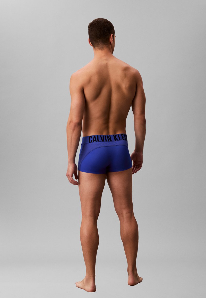 Blauwe boxershorts met een zwart Calvin Klein-logo op de tailleband, nauwsluitend ontwerp, zachte textuur en gladde stof.