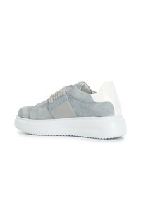 Grå mockask sneaker med vita blanka detaljer, elastisk sidopanel och texturerad greppsål. Har ett dekorativt pärlband över ovandelen.