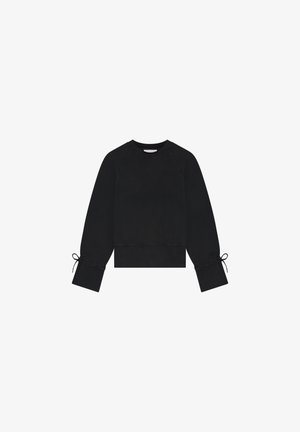 Black sweatshirt with raglan sleeves, cropped design, and tie details at the cuffs. Made of soft, textured material. Subtle logo on front.