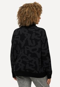 Schwarzer gestrickter Pullover mit abstraktem dunkelgrauem Muster, entspannte Passform, gerippter Halsausschnitt und Saum, weiche Textur, geeignet zum Layering.