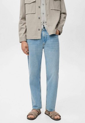 Lichtblauwe denim jeans met een relaxte pasvorm, gecombineerd met een lichtgrijze oversized shirt en bruine sandalen. Eenvoudig ontwerp, geen zichtbare patronen.