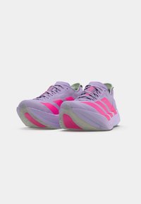 Lila Laufschuhe mit pinken Akzenten, die ein elegantes Design, eine glatte Textur und eine profilierte Sohle für Traktion aufweisen. Schnürsenkel und Markenlogo sind sichtbar.