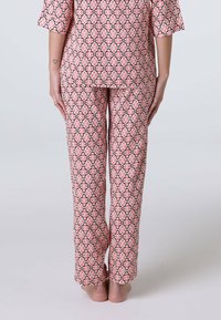 Set di pigiama in cotone caratterizzato da un motivo floreale geometrico in rosa e nero, con una maglietta morbida e pantaloni a gamba dritta in un tessuto leggero.