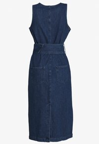 Ärmlös mörkblå denim midi-klänning med bred matchande bälte och två bakfickor, visad från baksidan mot vit bakgrund.