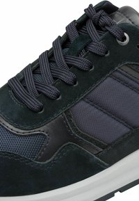 Herren Sneakers aus einer Mischung aus dunkelgrünem Wildleder, marineblauem Mesh und schwarzen synthetischen Überzügen. Dicke schwarze Schnürsenkel und eine strukturierte weiße Sohle.