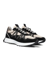 Zwarte en beige sneakers met een bovenwerk van suede en mesh, voorzien van witte veters, een dikke witte tussenzool en een gestructureerde zwarte buitenzool.