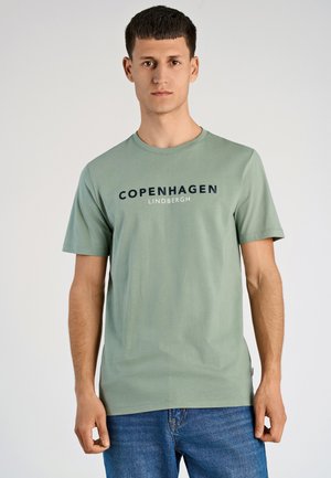 Grünes Baumwoll-T-Shirt mit kurzen Ärmeln, Rundhalsausschnitt und dunkelblauer Schrift "COPENHAGEN LINDENBERGH", die auf der Vorderseite aufgedruckt ist.