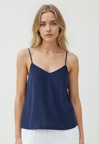 Navyblauwe cami-top met dunne verstelbare bandjes, V-hals en een relaxte pasvorm. Gemaakt van lichtgewicht, gestructureerde stof.