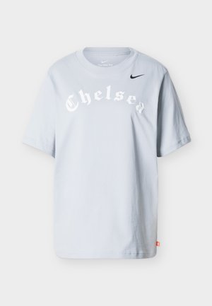 T-shirt Nike gris clair avec "Chelsea" en police Old English blanche et un petit swoosh Nike noir sur la poitrine.