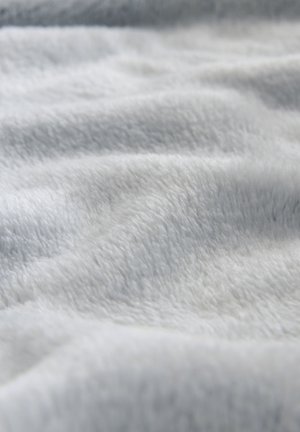 Tessuto grigio chiaro, morbido e vellutato con una consistenza liscia, che mostra onde delicate e sottili variazioni di tonalità in tutta la superficie.