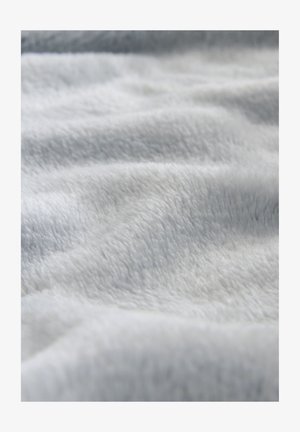 Material moale, plușat, de culoare gri deschis, cu o textură netedă, prezentând valuri fine și variații subtile de nuanță pe întreaga suprafață.