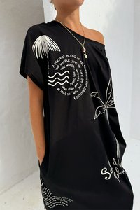 Czarna, oversize sukienka t-shirt z białym nadrukiem w postaci tekstu i motywów, w tym fal i liści palmowych. Wykonana z miękkiego, lekkiego materiału.