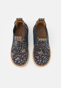 Modré slip-on boty s květinovým vzorem, s textilním svrškem, hnědou koženou podšívkou a texturovanou gumovou podrážkou. Pruhovaný akcent na patě.