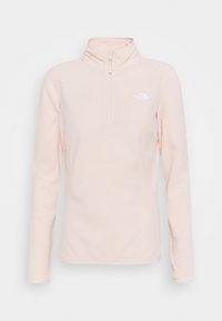 Sweatshirt en polaire rose clair avec un col zippé à mi-hauteur, des manches longues et un petit logo blanc sur la poitrine ; texture douce et design minimal.