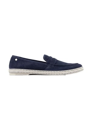 Navyblaue Wildleder-Slipper mit weißer Gummisohle, die ein gewebtes Muster und ein kleines rechteckiges Metallelement nahe der Ferse aufweist.