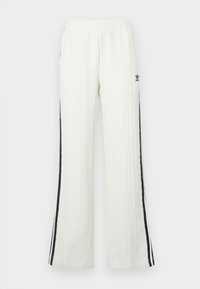 Calças Adidas brancas texturizadas com riscas pretas de lado e pequeno logótipo na parte superior da coxa esquerda, cintura elástica e pernas direitas.