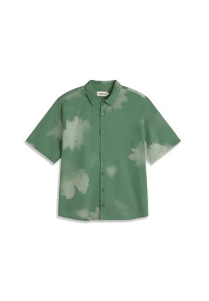 Camisa verde de manga corta con botones, cuello abierto y patrones claros, similares a decoloraciones, distribuidos por toda la tela.