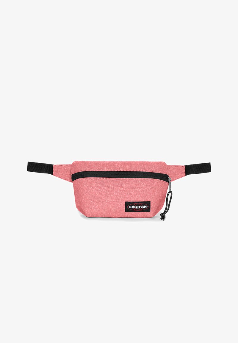 Vaaleanpunainen kangaskassi lanteilla, jossa on kiiltävä pinta, musta vetoketju, säädettävä hihna ja suurikokoinen Eastpak-logo.