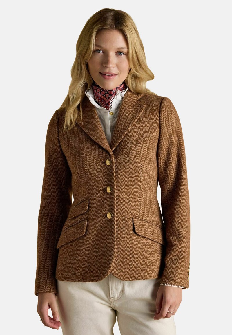 Blazer căptușit de culoare maro în model herringbone, cu croi ajustat, revere tăiate, butoane aurii și două buzunare frontale. Purtați peste o cămașă albă cu detalii imprimate.