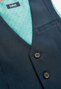 NavyblåTexturerad väst med två svarta knappar, en vänsterficka och en geometrisk mintgrön foder med vita mönster.