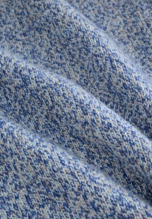 Paviršius su tekstūra įvairių mėlynos spalvos atspalvių, su pynimo raštu, kurį sudaro šviesiai ir tamsiai mėlyni siūlai, kuriantys minkštą ir jaukią išvaizdą.