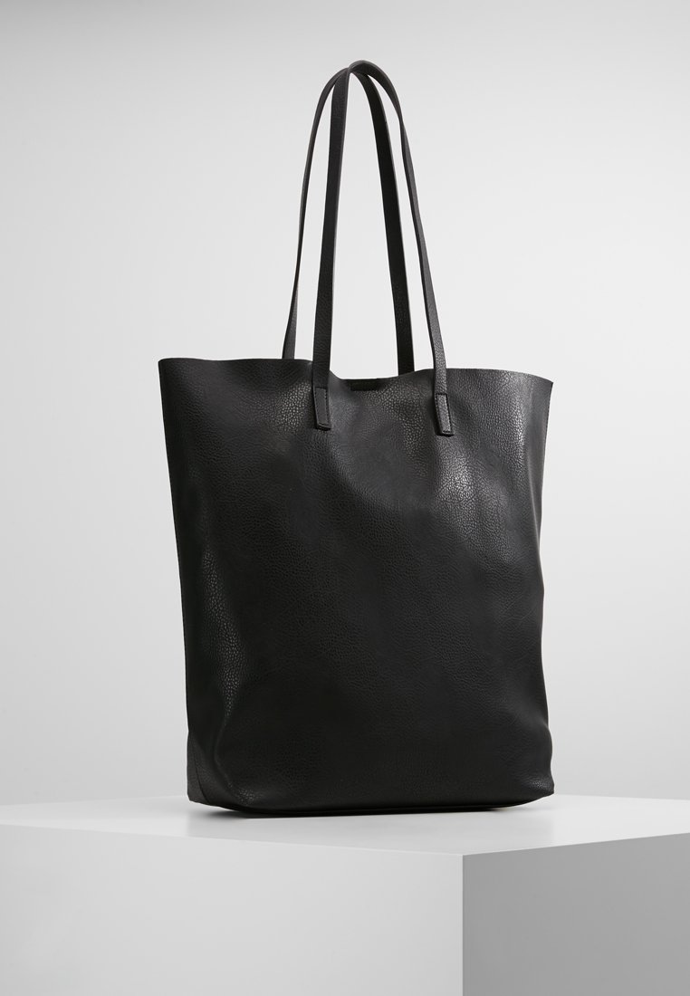 Schwarze Leder-Umhängetasche mit strukturierten Oberfläche, zwei langen Griffen und einem minimalistischen Design. Keine sichtbaren Beschläge oder Muster.