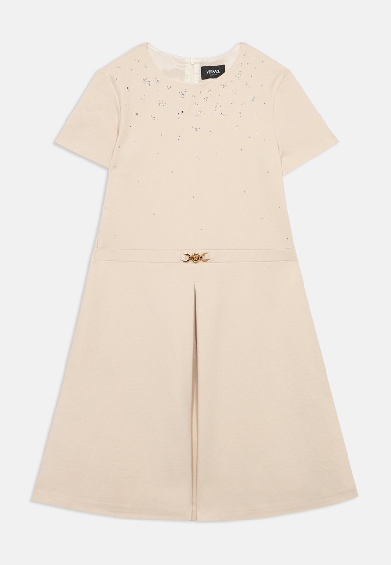 Robe beige à manches courtes avec de petits cristaux décoratifs sur le haut devant, un pli devant, et une fine ceinture avec boucle Medusa dorée.