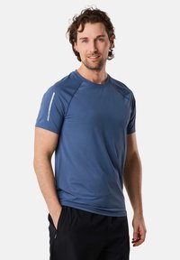 Herren-Sportshirt mit kurzen Ärmeln in Blau, aus leichtem Material mit glatter Textur und reflektierendem Akzent an der Schulter.