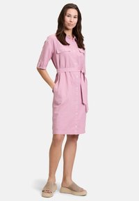 Różowa lniana sukienka z krótkimi rękawami, zapinana na guziki z przodu, z dwoma kieszeniami na piersiach, paskiem w talii oraz kieszeniami bocznymi, w zestawie z beżowymi platformami.