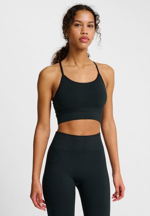 Schwarzer Sport-BH und hochgeschnittene Leggings, die ein eng anliegendes Design und eine weiche Textur mit minimalen Nähten und einem geprägten Logodetail aufweisen.