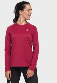 Langärmliges Sportshirt in tiefrot mit strukturiertem Stoff, Rundhalsausschnitt und weißem Logo auf der Brust. Entworfen mit Raglanärmeln.