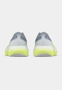 Szare buty do biegania z lekką siateczkową cholewką, neonowożółtymi akcentami na podeszwie, ergonomicznym kształtem i fakturowaną gumową podeszwą.