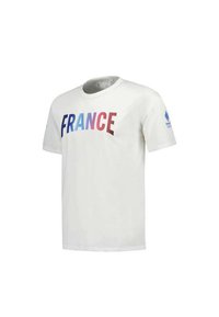 T-shirt en coton blanc avec "FRANCE" en dégradé de couleurs bleu, rose et rouge. Manches courtes et col rond avec un détail de logo sur la manche.