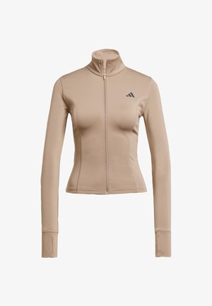 Giacca sportiva beige con collo alto, chiusura con zip integrale e maniche lunghe. Presenta il logo Adidas sulla parte superiore sinistra. Texture liscia.